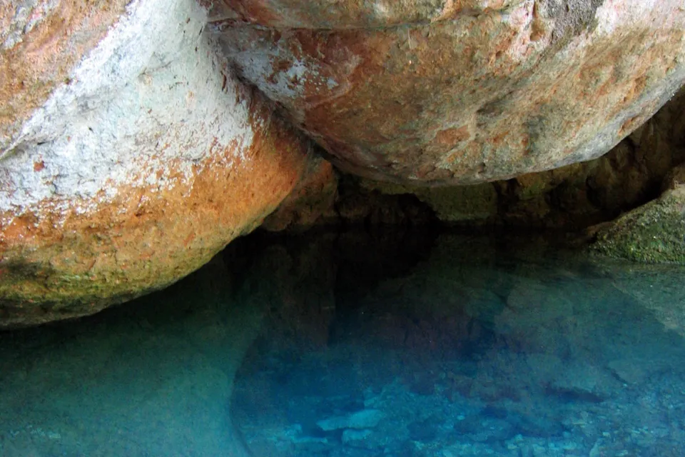 La vasque d'eau turquoise de la source de l'Avy, dite les fesses de Madame, sous ses rochers arrondis