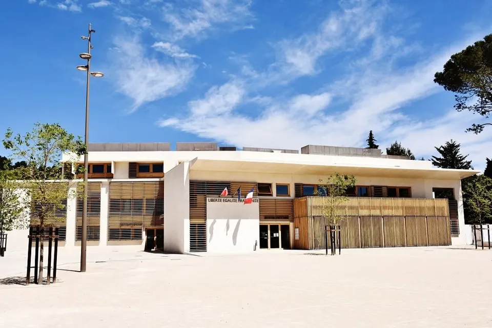 La nouvelle mairie de Grabels, bâtiment blanc et bois sur son esplanade, sous un ciel bleu