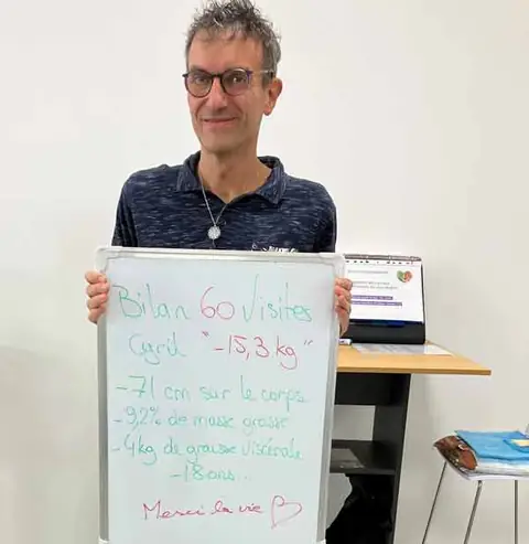 Au club, un membre souriant montre le bilan écrit sur son ardoise